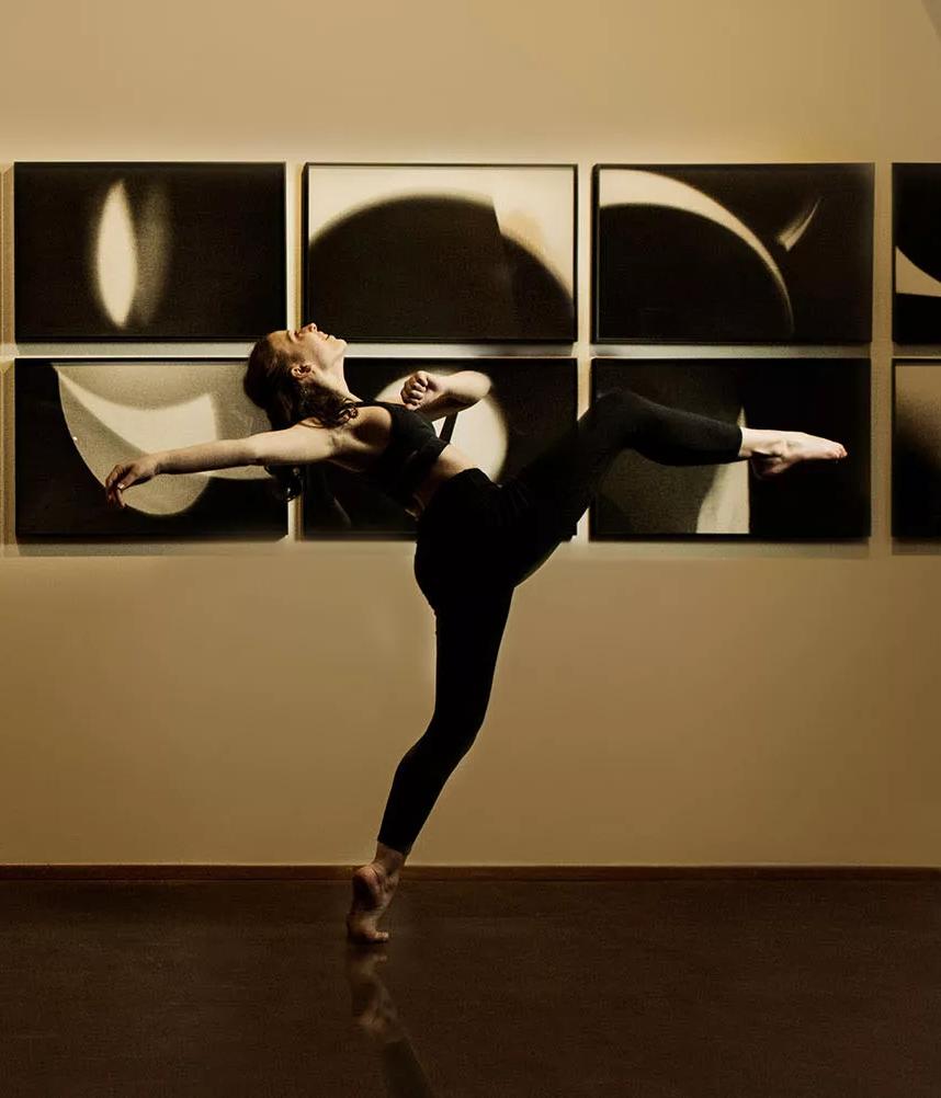 舞者身着黑色在黑白抽象照片前