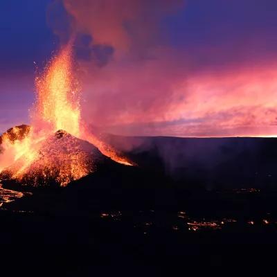 冰岛火山喷发的熔岩映衬着美丽的粉红色和蓝色的日落.